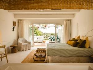 a bedroom with a bed and a large window at Morvedra Nou Luxury Boutique Hotel - Adults Only in Ciutadella