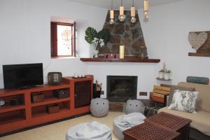 sala de estar con TV y chimenea en Finca Esther, en Las Palmas de Gran Canaria
