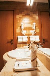 a bathroom with a tub and a sink with towels at AYA Addis Hotel in Addis Ababa