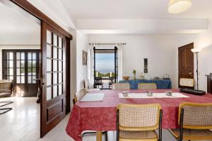a dining room with a table and chairs and a couch at Alto da Praia Villa in Colares
