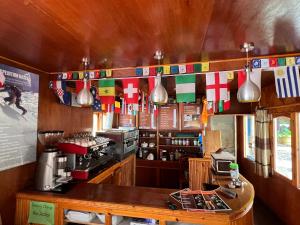 a kitchen with a coffee shop with flags on the wall at Mount kailash lodge and resturant , Monjo in Monjo