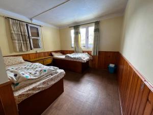 a small room with two beds and a window at Mount kailash lodge and resturant , Monjo in Monjo
