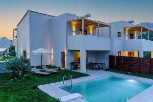 a house with a swimming pool in front of it at Increteblue Suites in Plakias