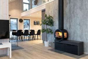 a fireplace in a living room with a table at Vikran Seaside Lodge in Straumsjøen