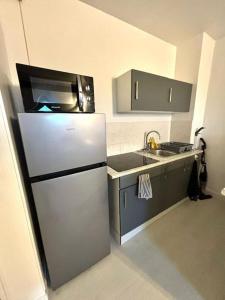 eine kleine Küche mit Kühlschrank und Spüle in der Unterkunft New Studio Cosy - Proche RER et centre ville in Brétigny-sur-Orge