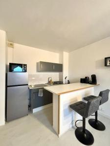 a kitchen with a counter and a chair in it at New Studio Cosy - Proche RER et centre ville in Brétigny-sur-Orge