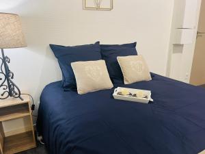 a blue bed with a tray of candles on it at Le 2 - Grand studio avec coin repas Caen Port in Caen
