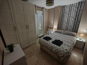 a bedroom with a bed with two black pillows on it at Tranquilo y Elegante in Cenes de la Vega