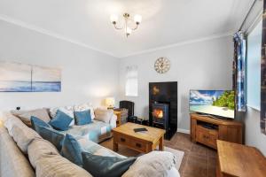a living room with a couch and a tv at Farm stay outside Canterbury in Stelling