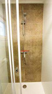 a shower with a glass door in a bathroom at Chalet Sjaantje in Egmond aan den Hoef