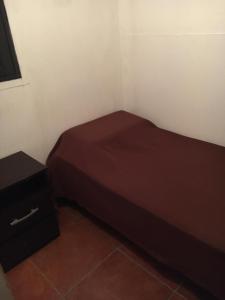 Habitación pequeña con cama y mesita de noche en Proa Amarilla, en Punta del Este