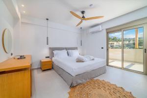 a bedroom with a bed and a ceiling fan at Increteblue Suites in Plakias
