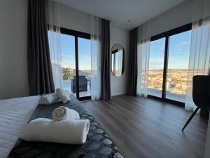 - une chambre avec un lit et 2 serviettes dans l'établissement Vila Pombal Tomar - Luxury Apartment with private pool and Castle View, à Tomar