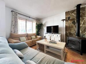 a living room with a couch and a tv at La Casa Ibicenca in Benicàssim