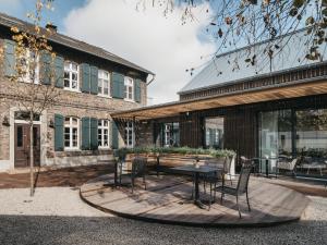 a patio with a table and chairs in front of a building at Landhotel Voshövel in Schermbeck