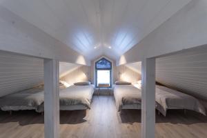 a room with three beds and a window at Vikran Seaside Lodge in Straumsjøen