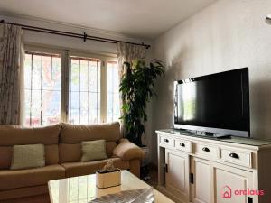 uma sala de estar com um sofá e uma televisão de ecrã plano em La Casa Ibicenca em Benicàssim