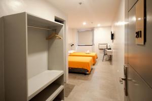 Habitación pequeña con cama y baño. en Hotel Lucca, en Legazpi