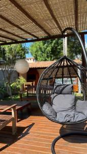 un sillón colgante con almohadas en el patio en Pousada Tropicália, en Arraial d'Ajuda