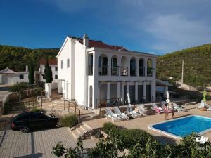 una gran casa blanca con piscina frente a ella en Apartment Olea, en Marina