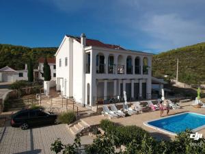 a large white house with a swimming pool in front of it at Apartment Olea in Marina