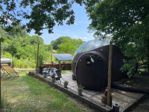 a dome tent in a yard with a table and chairs at La bulle bien belge avec jacuzzi in Lasne