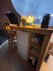 a desk with a lamp and a table and chairs at La bulle bien belge avec jacuzzi in Lasne