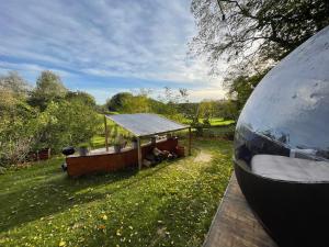 a view of a house with a tent in the grass at La bulle bien belge avec jacuzzi in Lasne