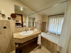 a bathroom with a sink and a tub and a mirror at Hotel Kazar in Ontinyent +61 photos