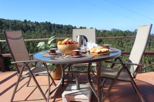 a table with a bowl of fruit and bread on a balcony at Finca Esther in Las Palmas de Gran Canaria