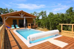 a pool on a deck next to a house at Maison CLAPAS in Saint Alban Auriolles