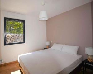a bedroom with a white bed and a window at Maison CLAPAS in Saint Alban Auriolles