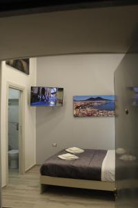 una camera da letto con un letto e una TV a parete di Casa We Love Napoli a Napoli