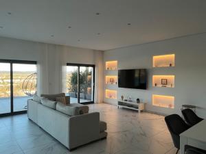 un soggiorno con divano e TV di Vila Pombal Tomar - Luxury Apartment with private pool and Castle View a Tomar