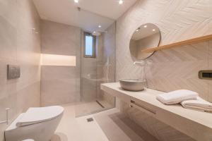 ein Badezimmer mit einem WC, einem Waschbecken und einem Spiegel in der Unterkunft Increteblue Suites in Plakias