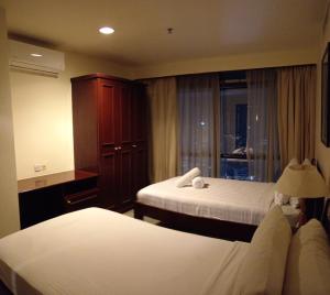 a hotel room with two beds and a window at CITY APARTMENT at TIMES SQUARE in Kuala Lumpur