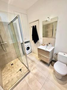 y baño con ducha, aseo y lavamanos. en Appartement 50m2 avec terrasse idéalement situé, en Boulogne-Billancourt