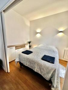 1 dormitorio con 1 cama con 2 toallas en Appartement 50m2 avec terrasse idéalement situé, en Boulogne-Billancourt
