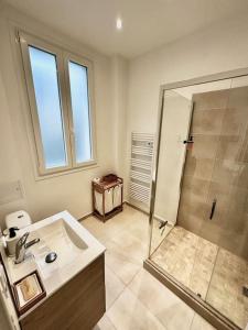 y baño con lavabo y ducha. en Appartement 50m2 avec terrasse idéalement situé, en Boulogne-Billancourt