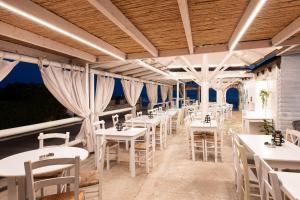 une rangée de tables et de chaises dans un restaurant dans l'établissement Barefoot Contessa, à Lourdhata