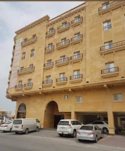 a large building with cars parked in front of it at اجنحة أروى سويتس الدمام Arwa Suites Dammam in Dammam