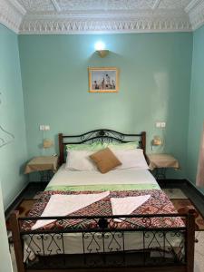a bedroom with a bed with blue walls at Diyar Timnay in Moulay Idriss Zerhoun