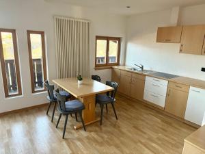 a kitchen with a table and chairs in a room at Ferienwohnungen Preiss in Schenna