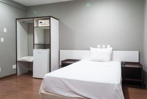1 dormitorio con 1 cama blanca grande y armario en Master Express Cidade Baixa - Próximo à UFRGS e à Santa Casa, en Porto Alegre