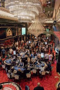 Grand Bellagio Batumi Convention & Casino Hotel في باتومي: زحمة الناس جالسين على الطاولات في غرفة كبيرة