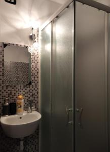 ミラノにあるラ カーサ デッラ ツィアのバスルーム(洗面台、ガラス張りのシャワーブース付)