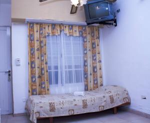 Departamentos 27 في سان كليمنتي ديل تويو: غرفة نوم بها سرير وتلفزيون على الحائط