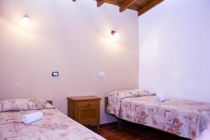 Departamentos 27 في سان كليمنتي ديل تويو: سريرين في غرفة بجدران بيضاء وأرضية خشبية