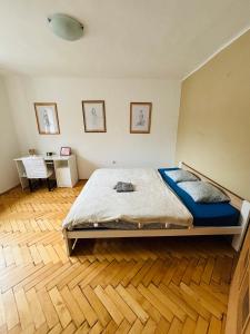 a bedroom with a bed and a wooden floor at Provence style apartment in Košice