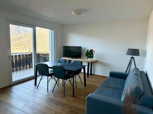 a living room with a blue couch and a table at Ferienwohnungen Preiss in Schenna